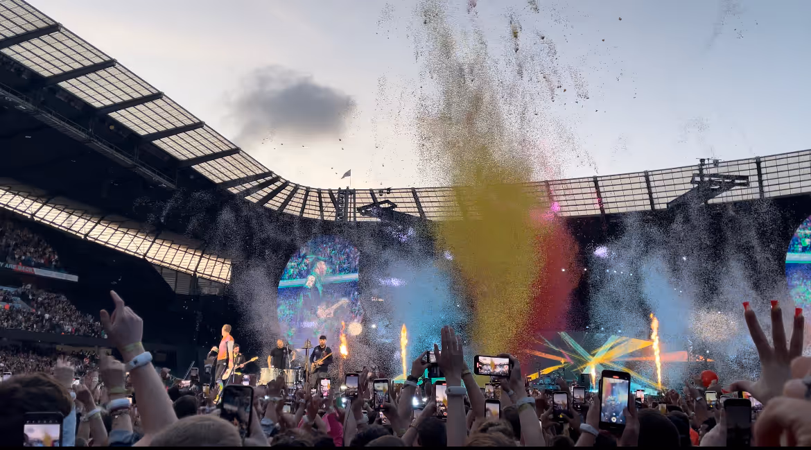 Purple and white confetti with fireworks at a Coldplay concert