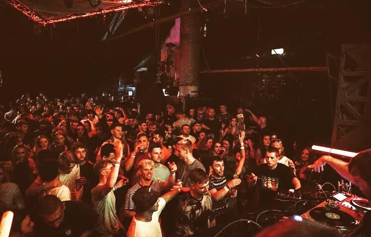 A historic building is lit up with a pub to the right called The Shipping Forecast