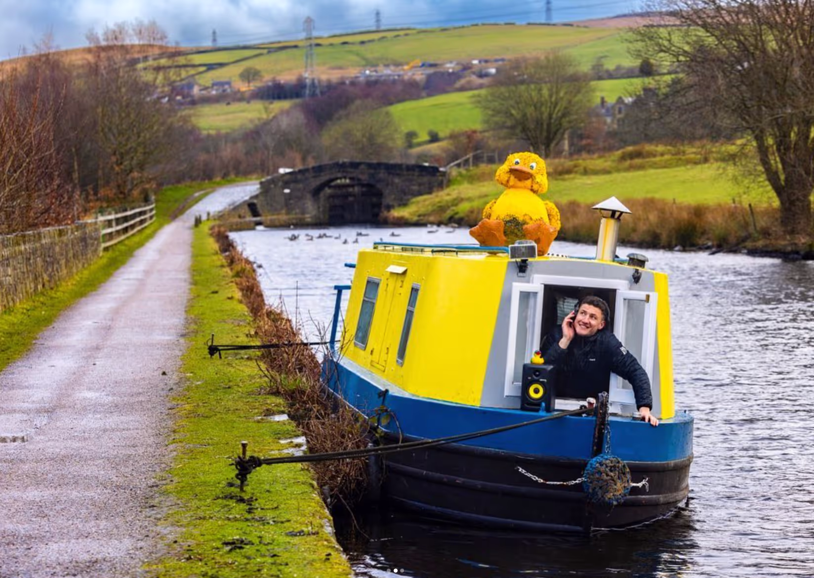 A man is poised on a boat, gazing out at the water, embodying tranquility and adventure.