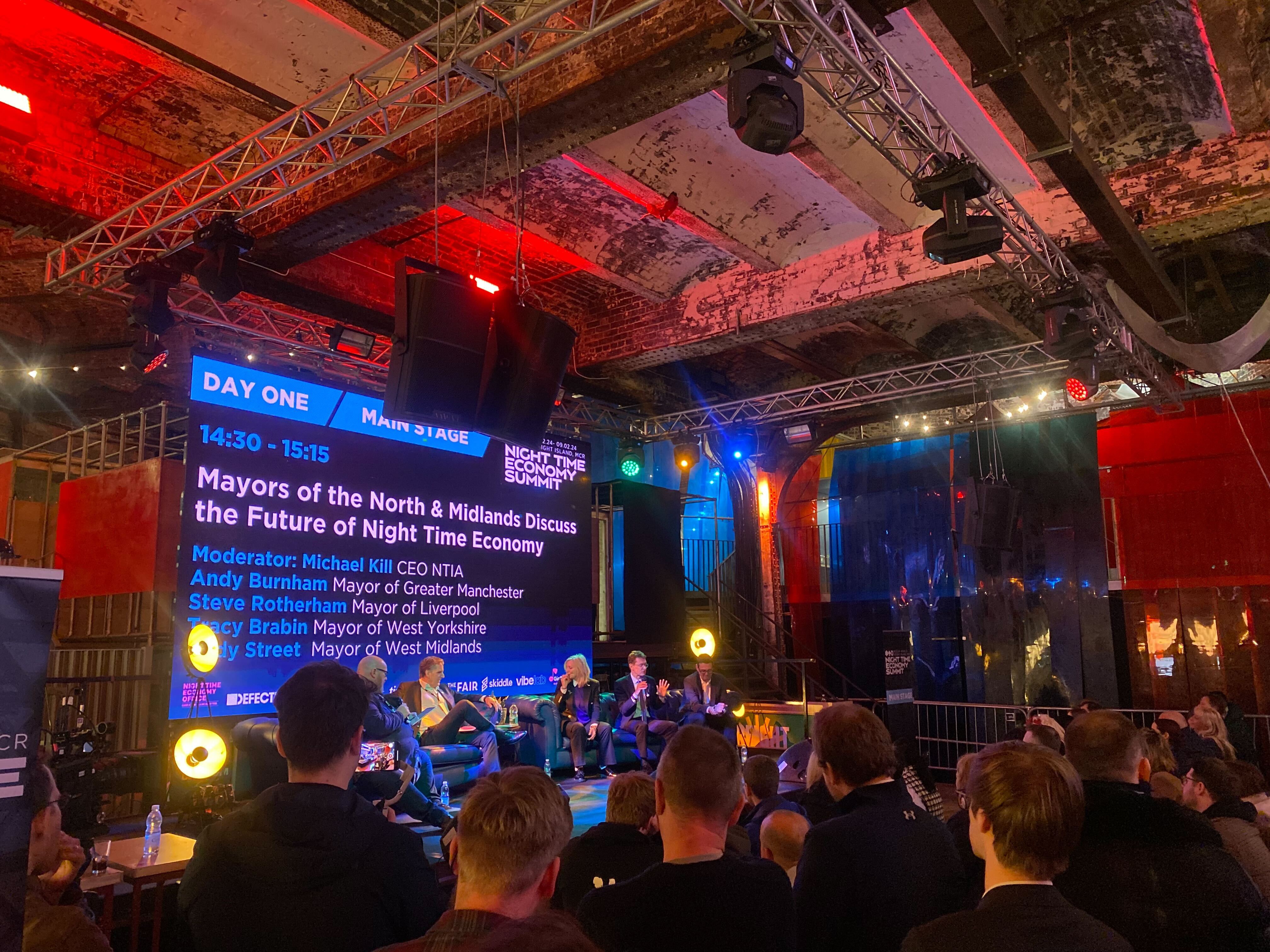 A large crowd of people gathered in a spacious room, engaged in conversation and activities