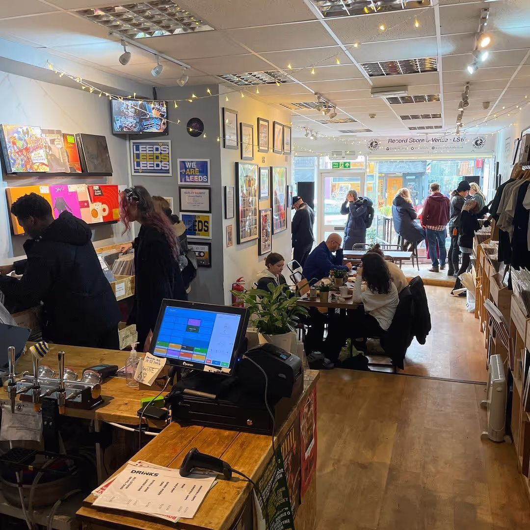 A busy shop interior featuring customers browsing and a computer on the counter