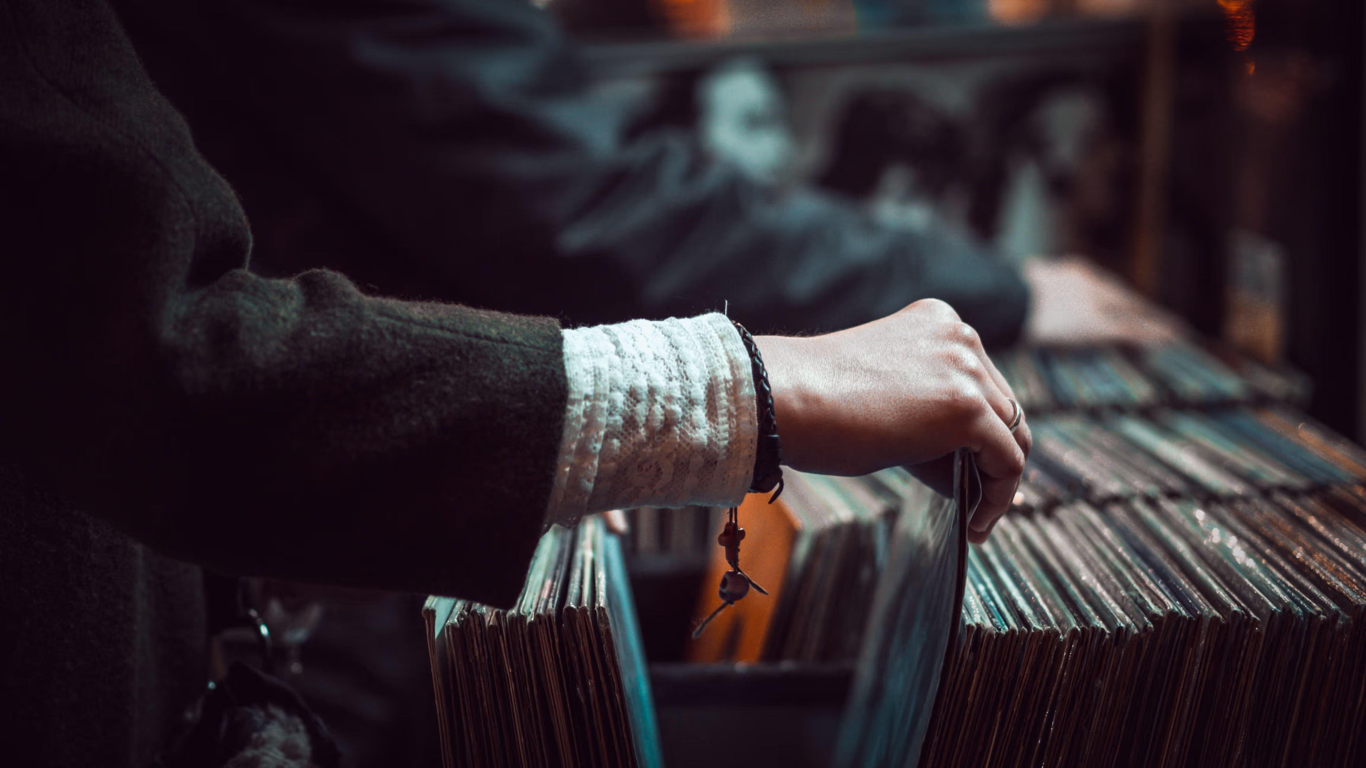 A hand flipping through a stack of vinyls