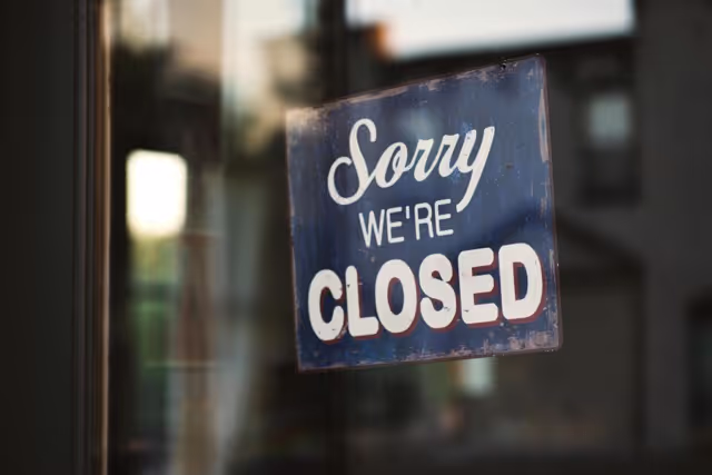 A sign stating "we are closed" hangs on a door 
