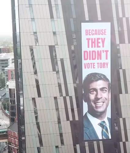 Advertisement displayed on the side of a building in Manchester, showcasing vibrant colors and engaging visuals