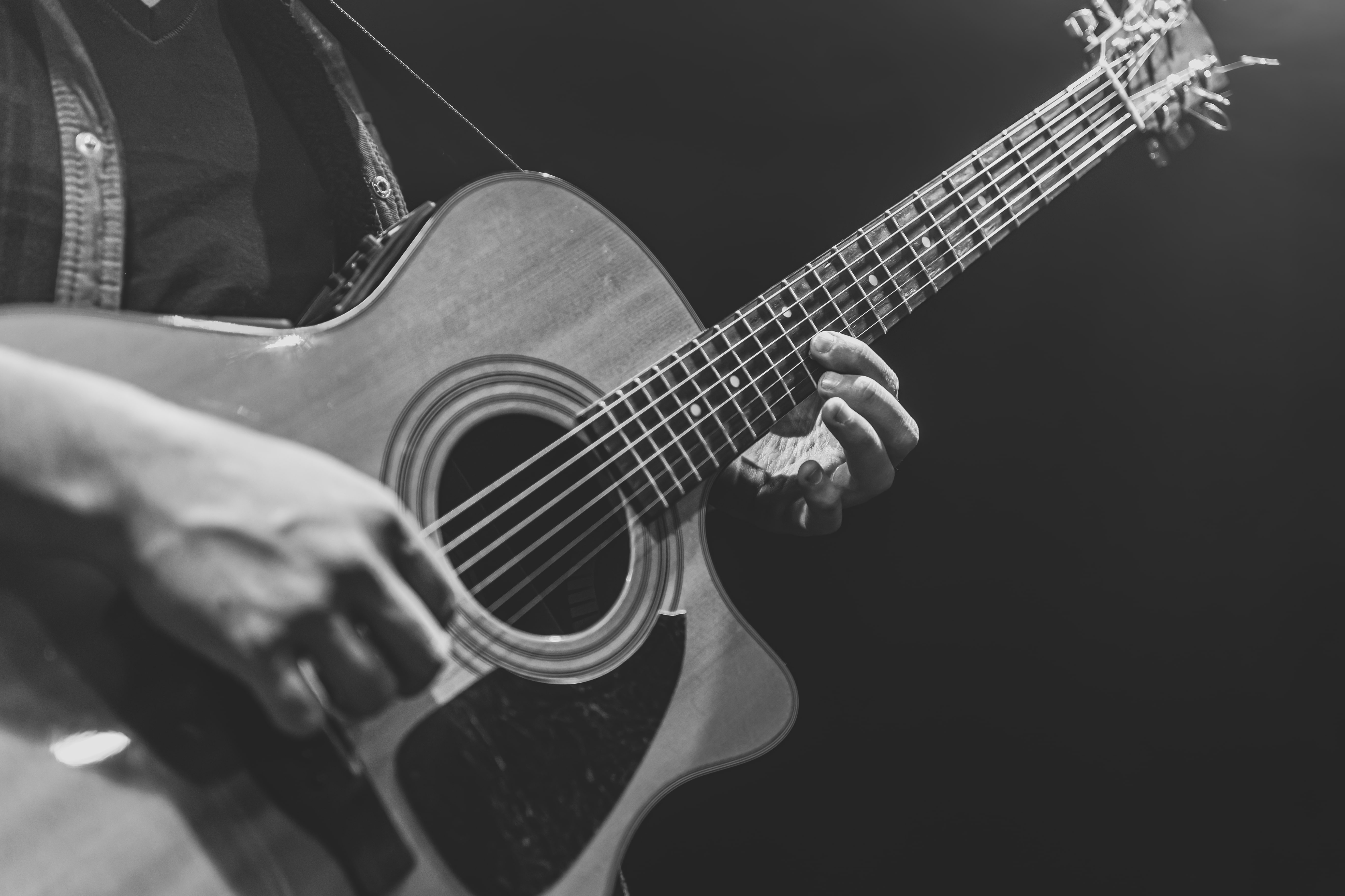 Black and white image of a man holding a guitar.