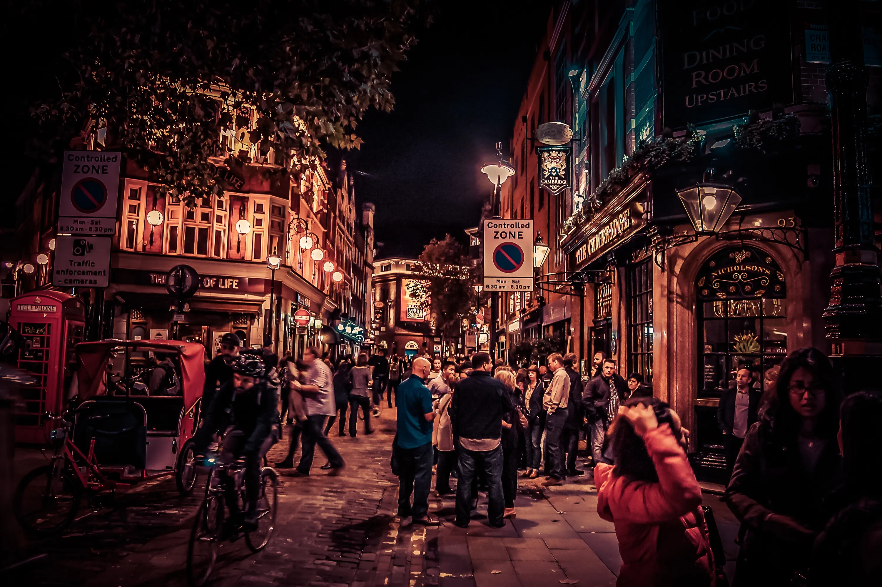 The UK nightlife with people outside a couple of bars in the night
