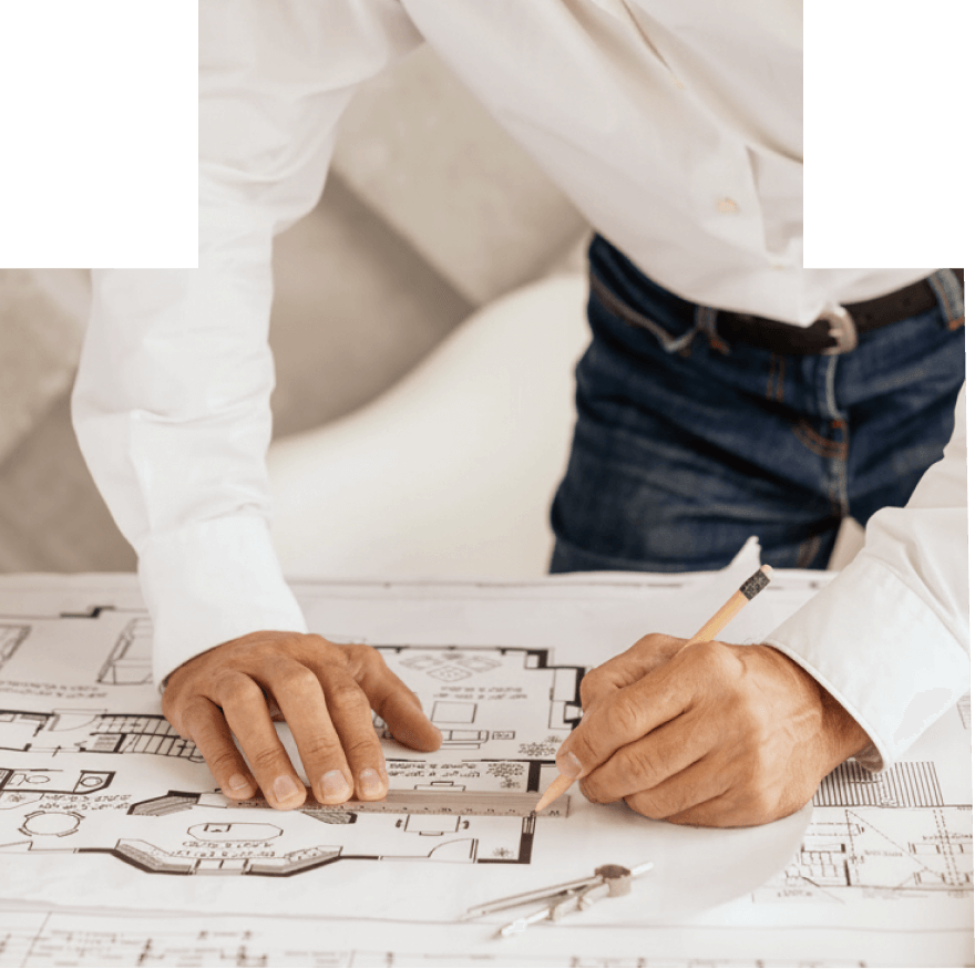 Architect or designer drawing on a building blueprint with a ruler and pencil.