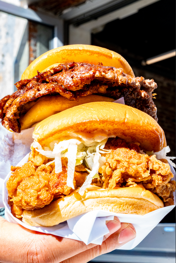 Deux sandwiches au poulet frit, l’un avec du poulet croustillant et de la laitue, l’autre avec un filet de poulet frit croustillant dans un petit pain doré.