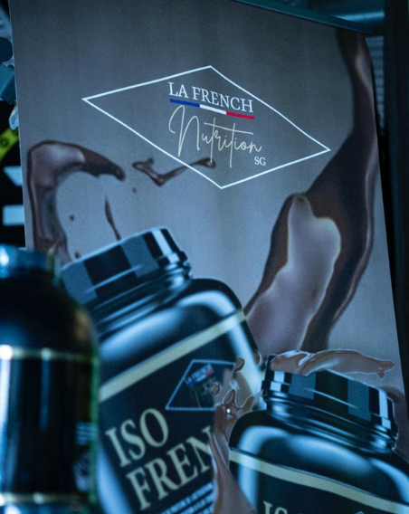 Produits de nutrition sportive La French Nutrition avec éclaboussures de chocolat autour des bouteilles.