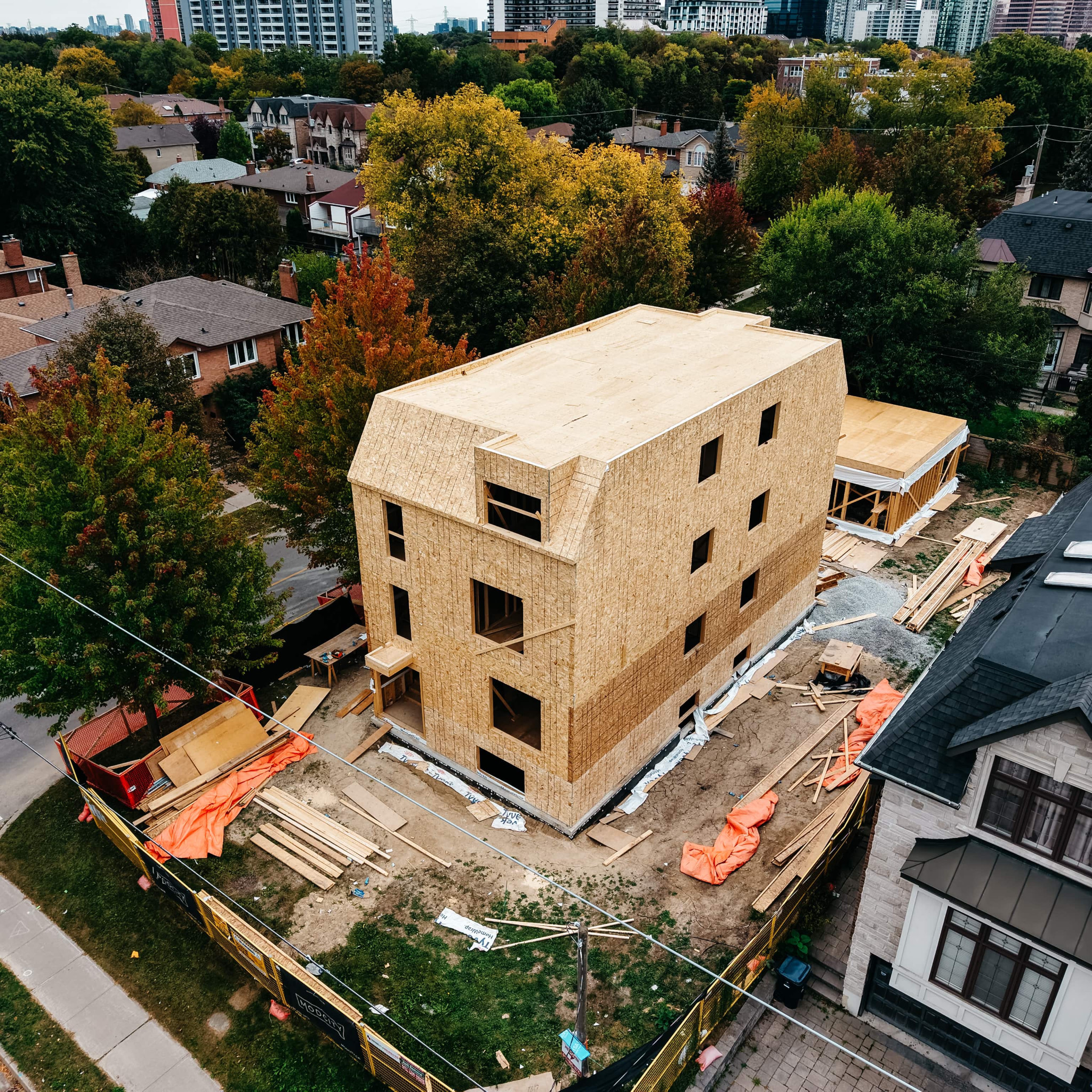 Aerial view of Willowdale during construction, showing the wood-sheathed main building and surrounding neighbourhood.