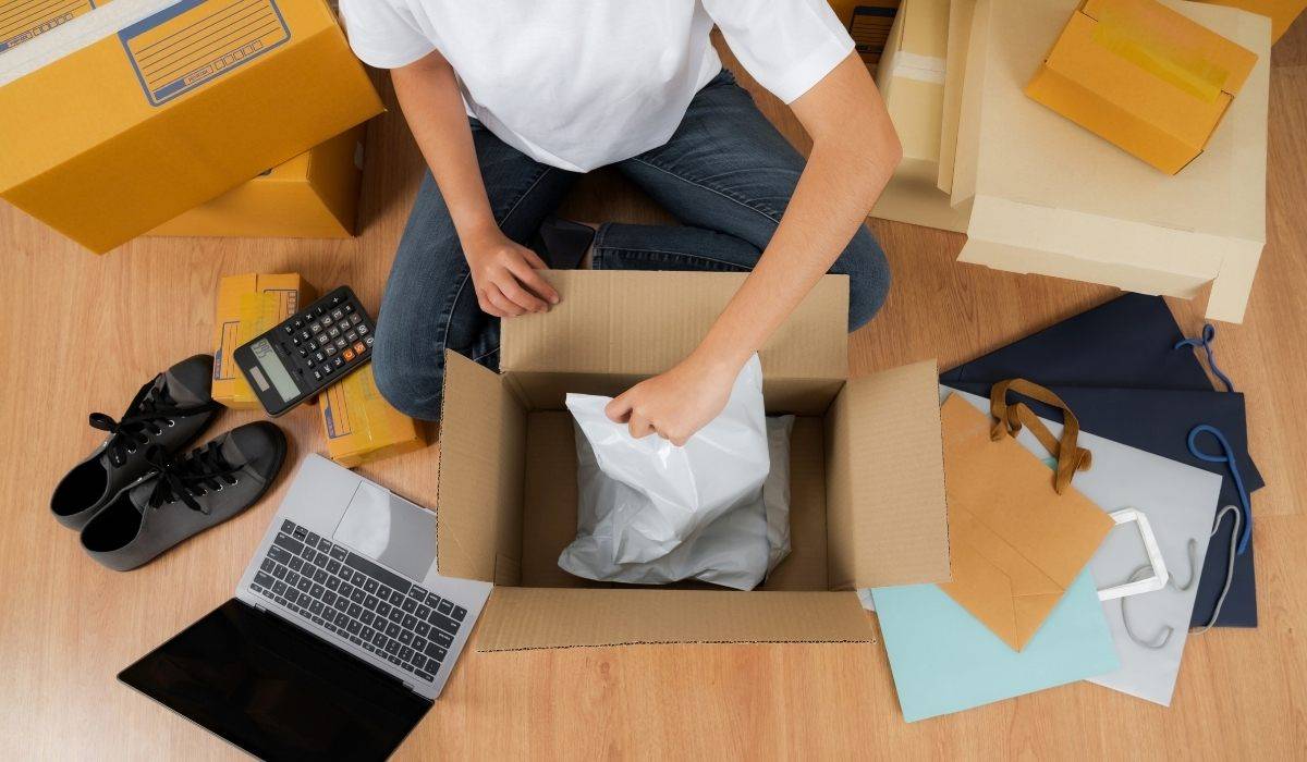 Após vender pela internet, homem embala produtos para entregar a cliente