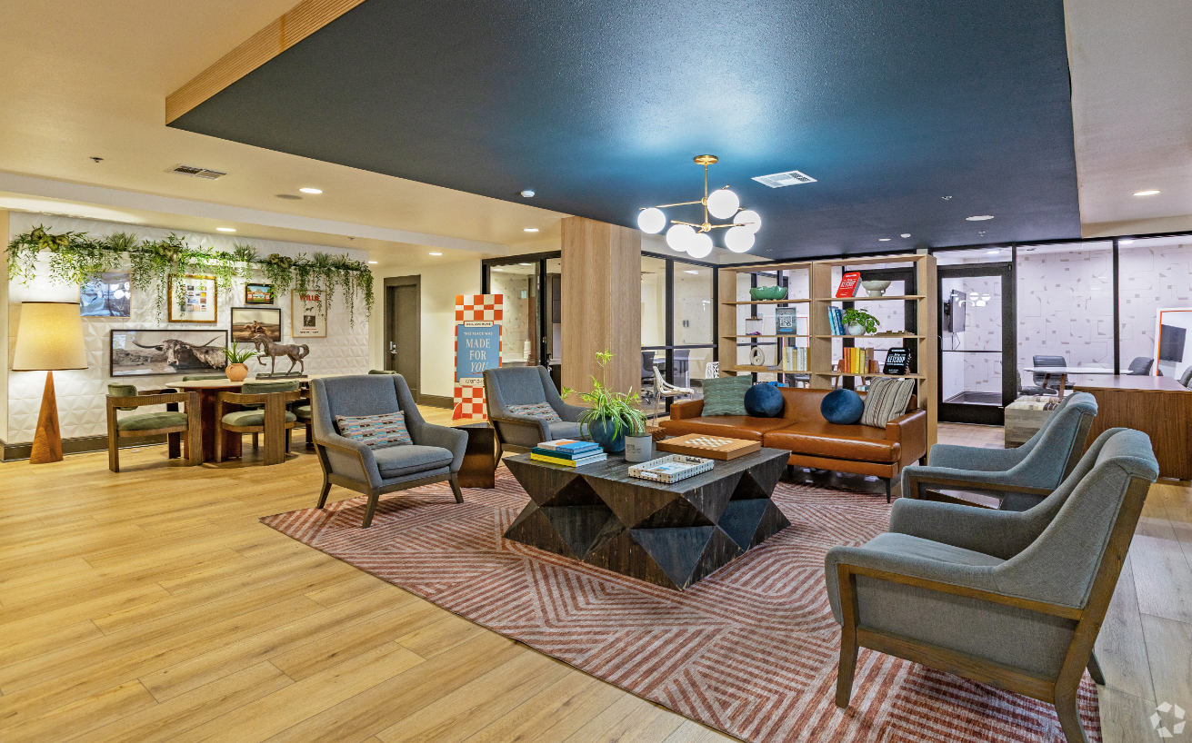 Front lobby with sofas, chairs, coffee table, and book shelves