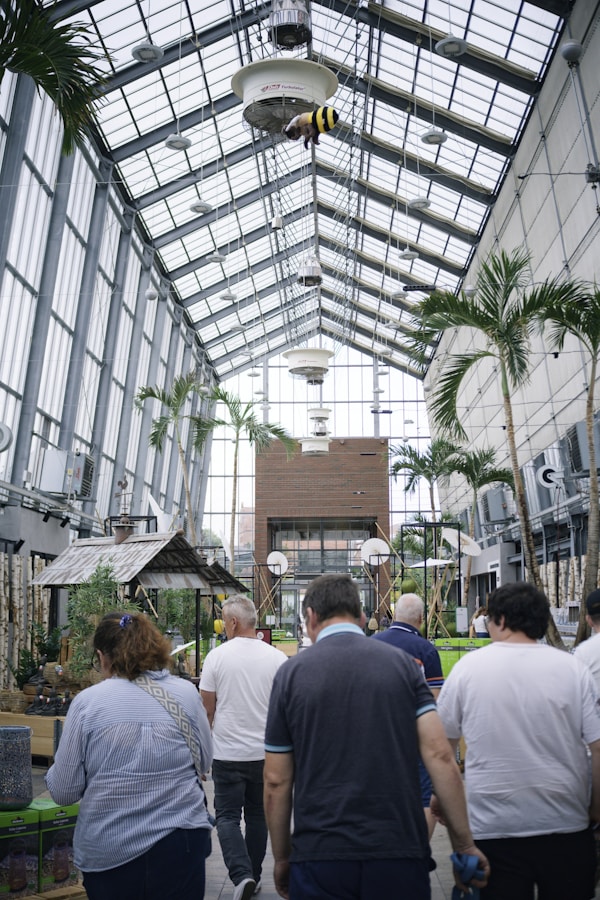 People explore a greenhouse with a unique architectural design.