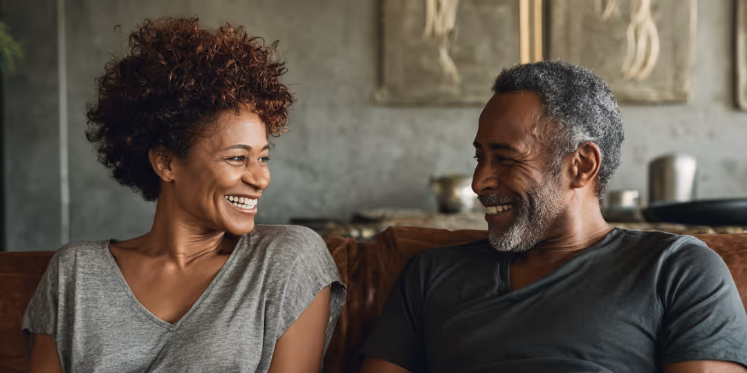 Couple smiling at each other on a couch