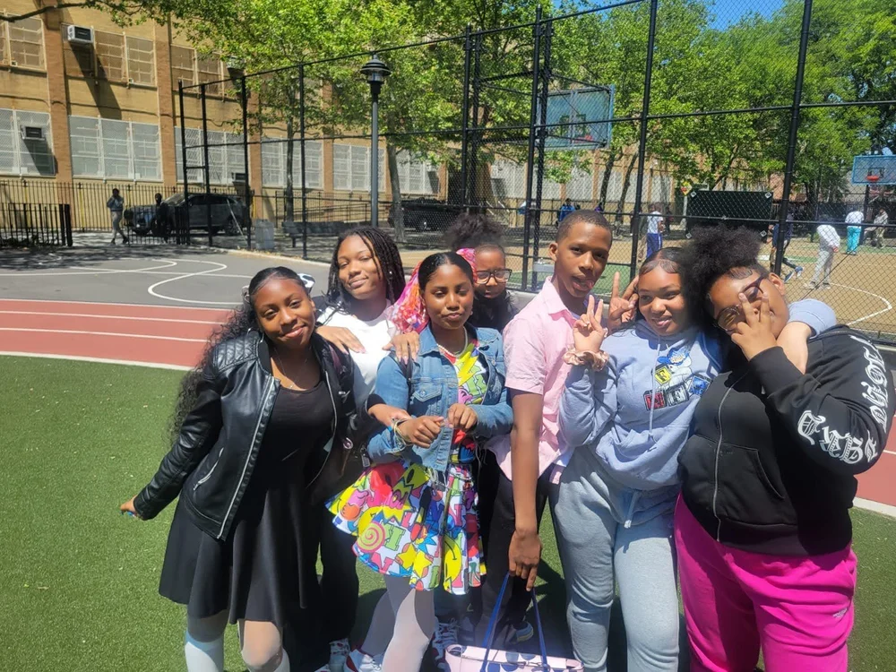 Students posing together on school outdoor basketball court