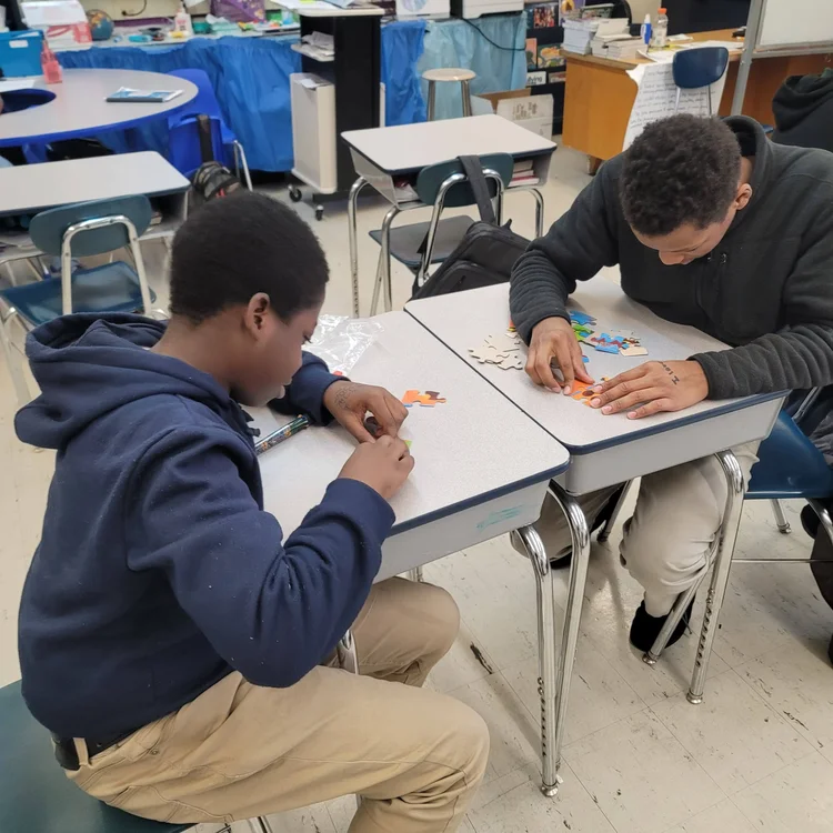 Two students working together on a puzzle activity at their desks