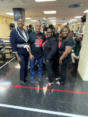 Four school staff members posing together in school cafeteria