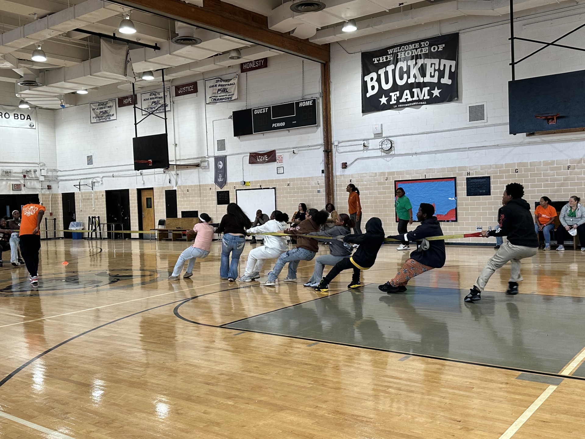 Students competing in a tug of war game in school gymnasium