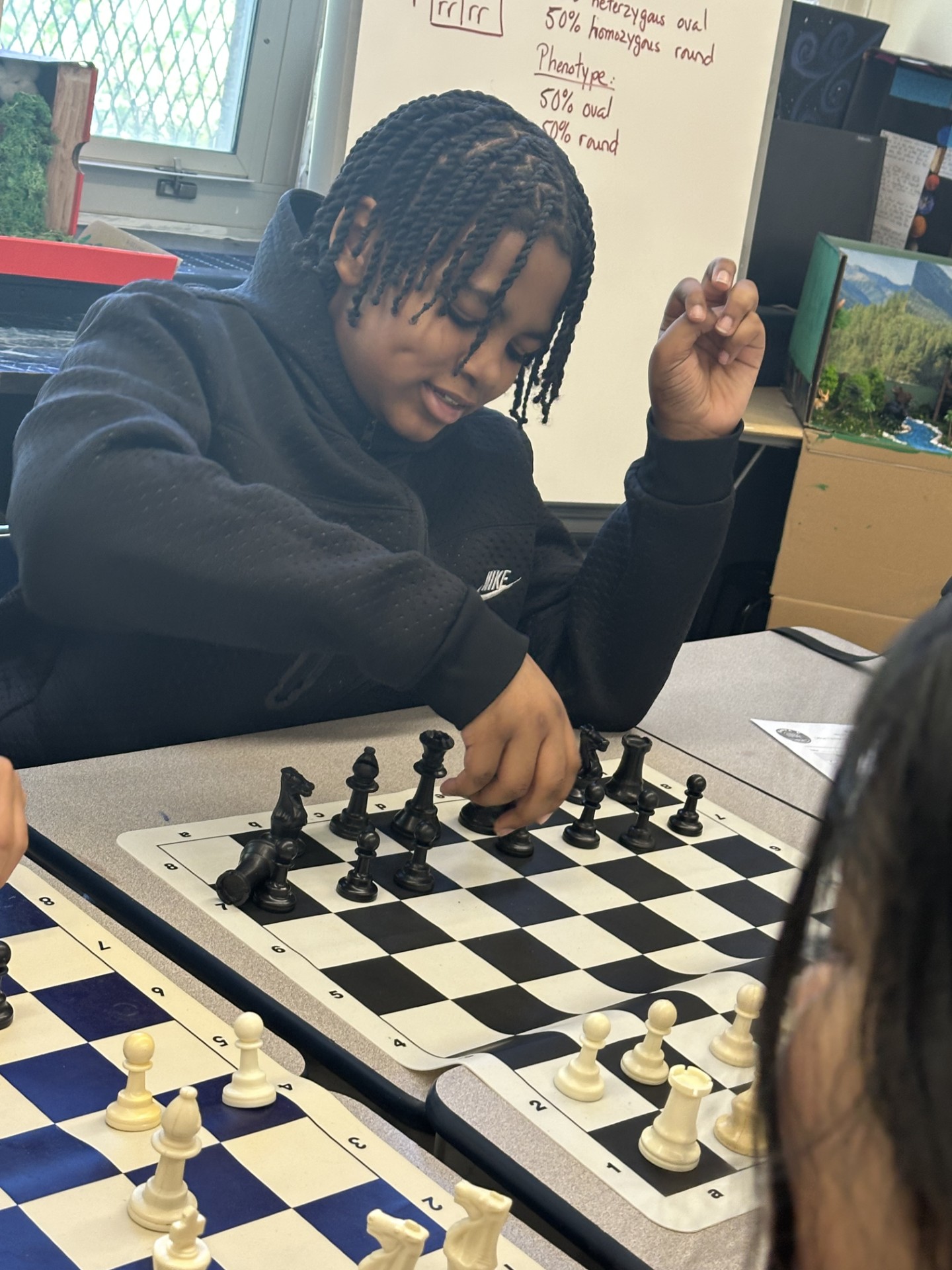 Student making a chess move during a classroom chess game