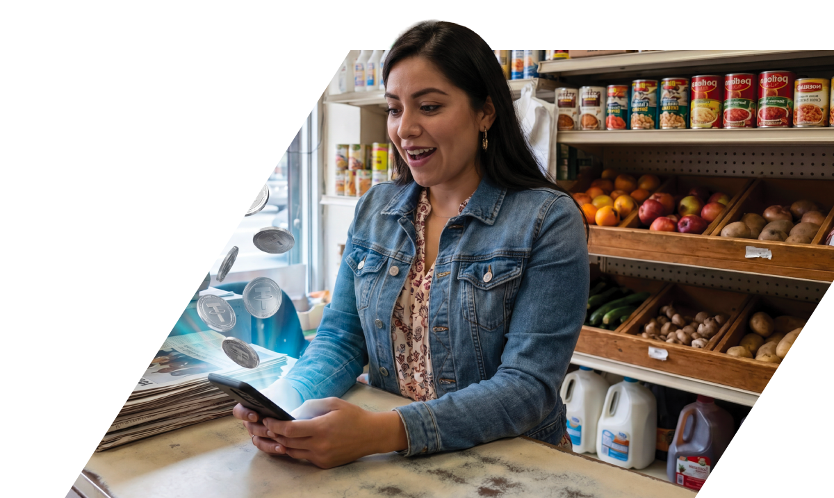 Mujer feliz usa un teléfono móvil en una tienda con frutas, verduras y productos en estantes.