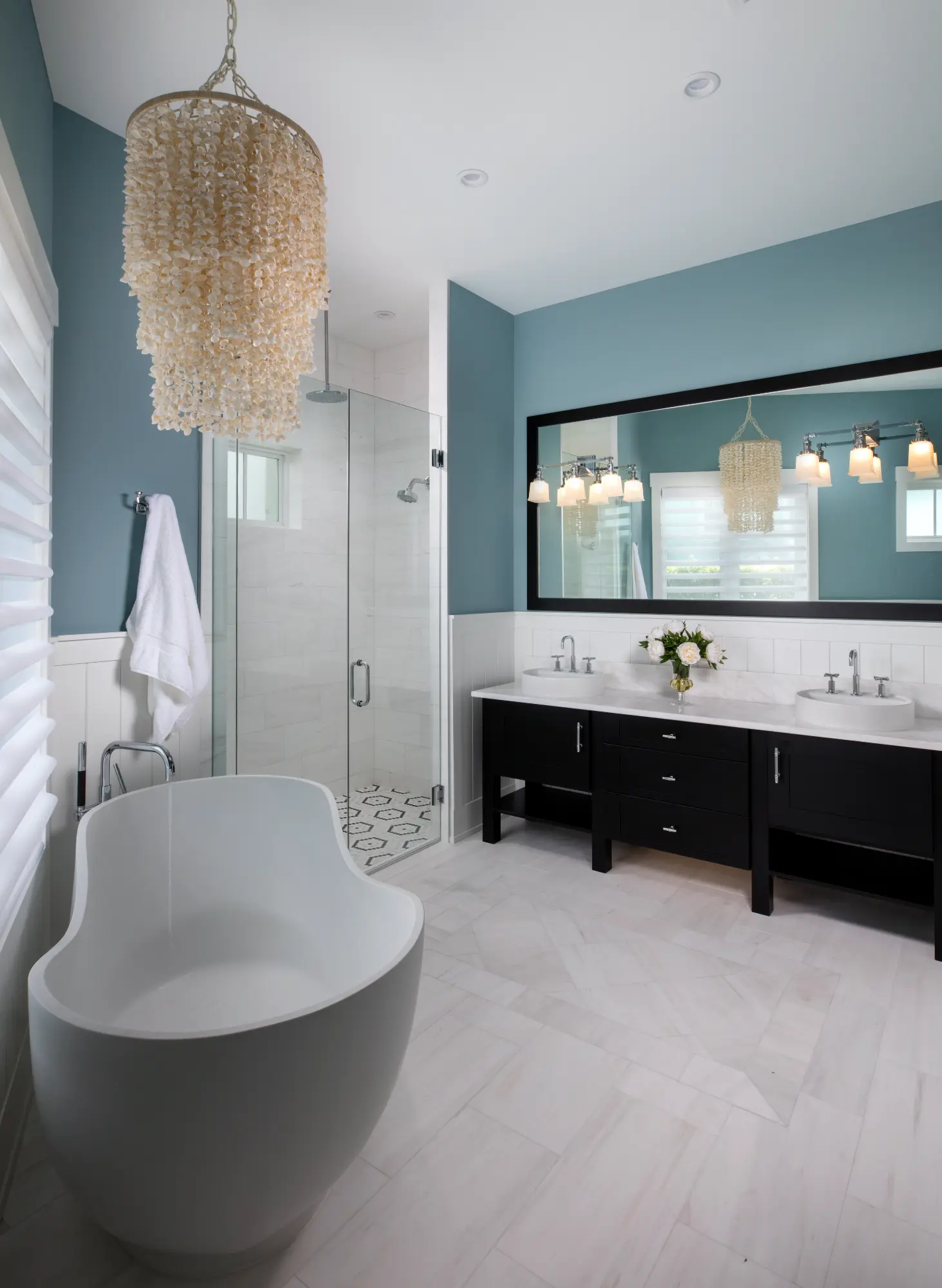 Modern bathroom with a freestanding bathtub, glass shower, and double vanity with a large mirror.