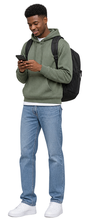 Young man wearing a green hoodie, blue jeans, white sneakers, and a black backpack, looking at and using a smartphone with a slight smile.