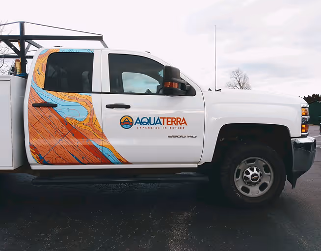 Custom vehicle wrap for Aquaterra with colorful graphic design and logo on white Chevy Silverado work truck