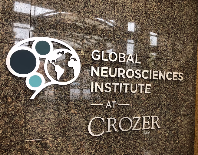 Custom dimensional wall sign for Global Neurosciences Institute at Crozer with logo and raised lettering on polished stone background