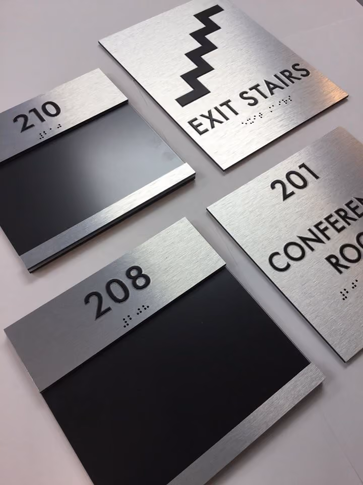 Brushed aluminum accessible room signs with braille for various locations