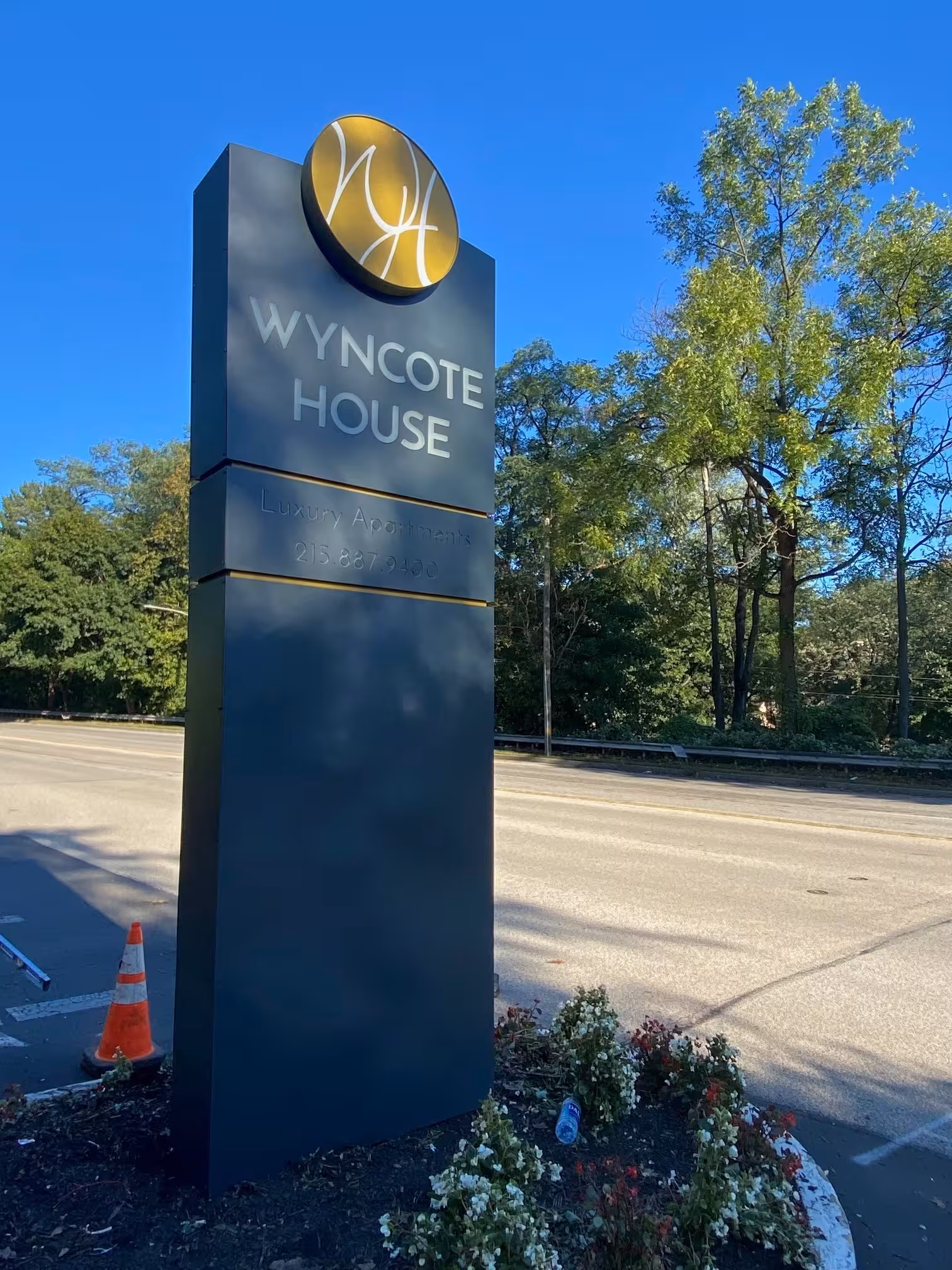 Modern black monument sign with gold logo and lettering