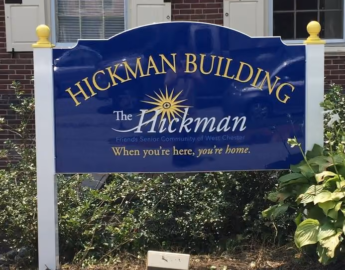 Exterior sign with building name held by two posts with ball finials