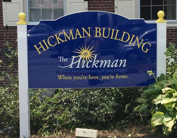 Blue and gold carved sign reading ‘Hickman Building – The Hickman, Friends Senior Community of West Chester, When you’re here, you’re home.