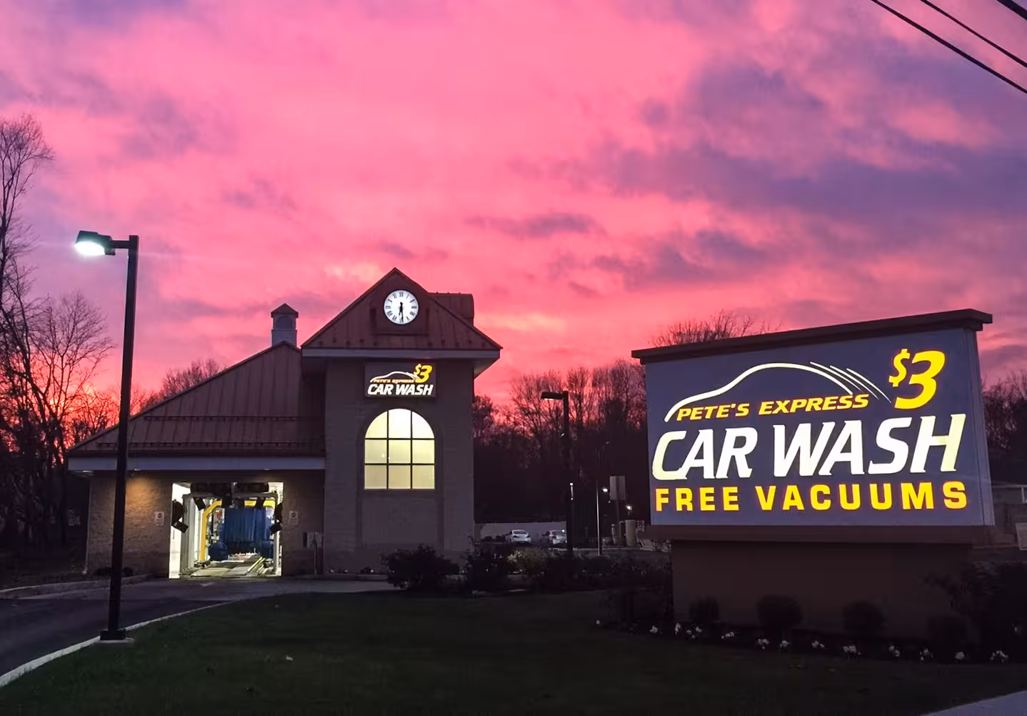 Illuminated monument sign for Pete’s Express Car Wash advertising $3 washes and free vacuums at sunset.