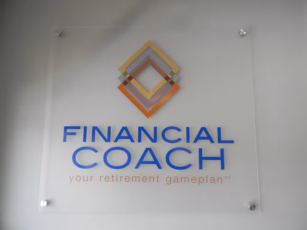 Acrylic wall sign with geometric logo and text reading ‘Financial Coach – your retirement gameplan.