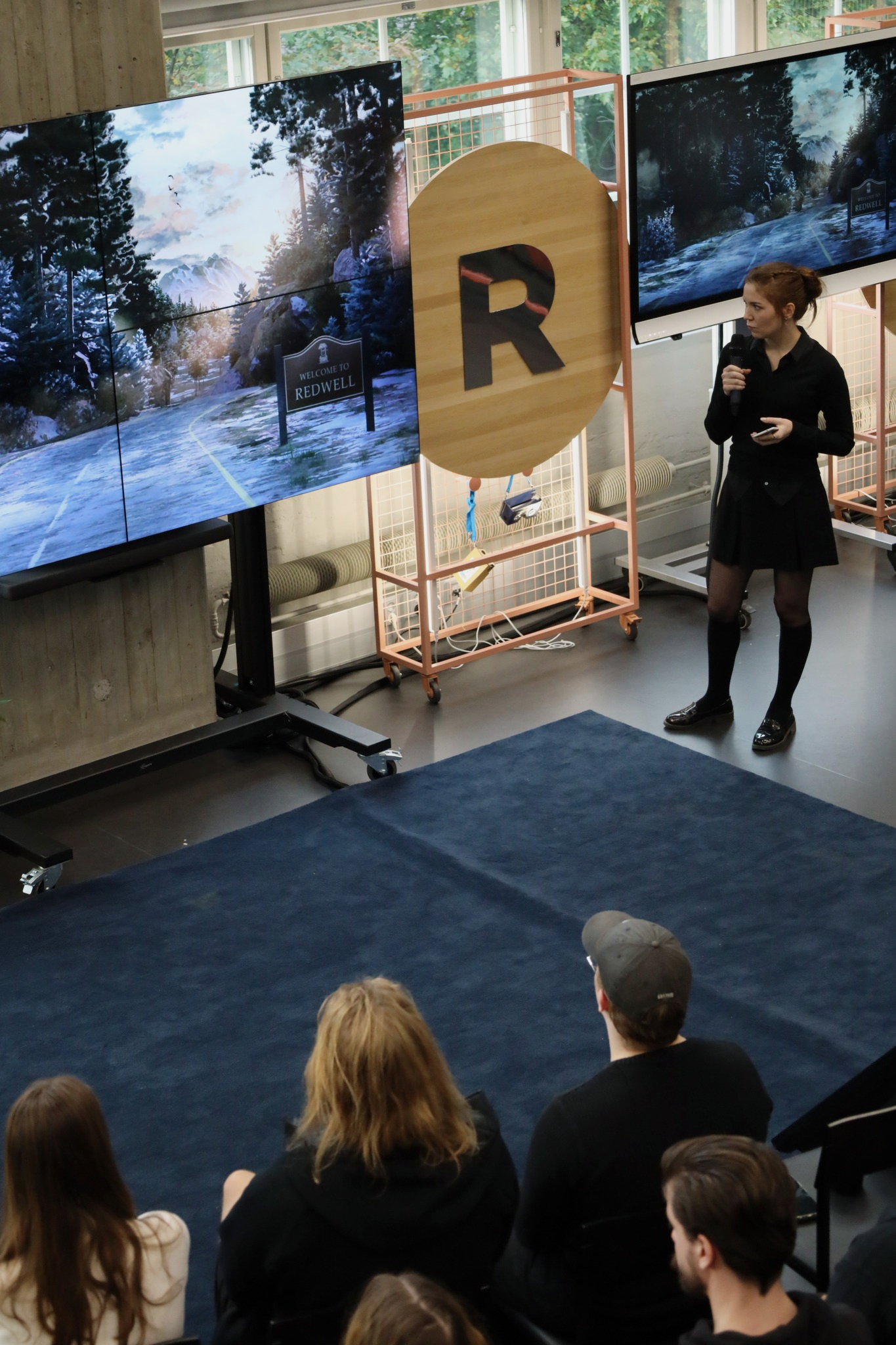 Josianne pitching on stage with a screenshot of Grave Regrets shown on screen.