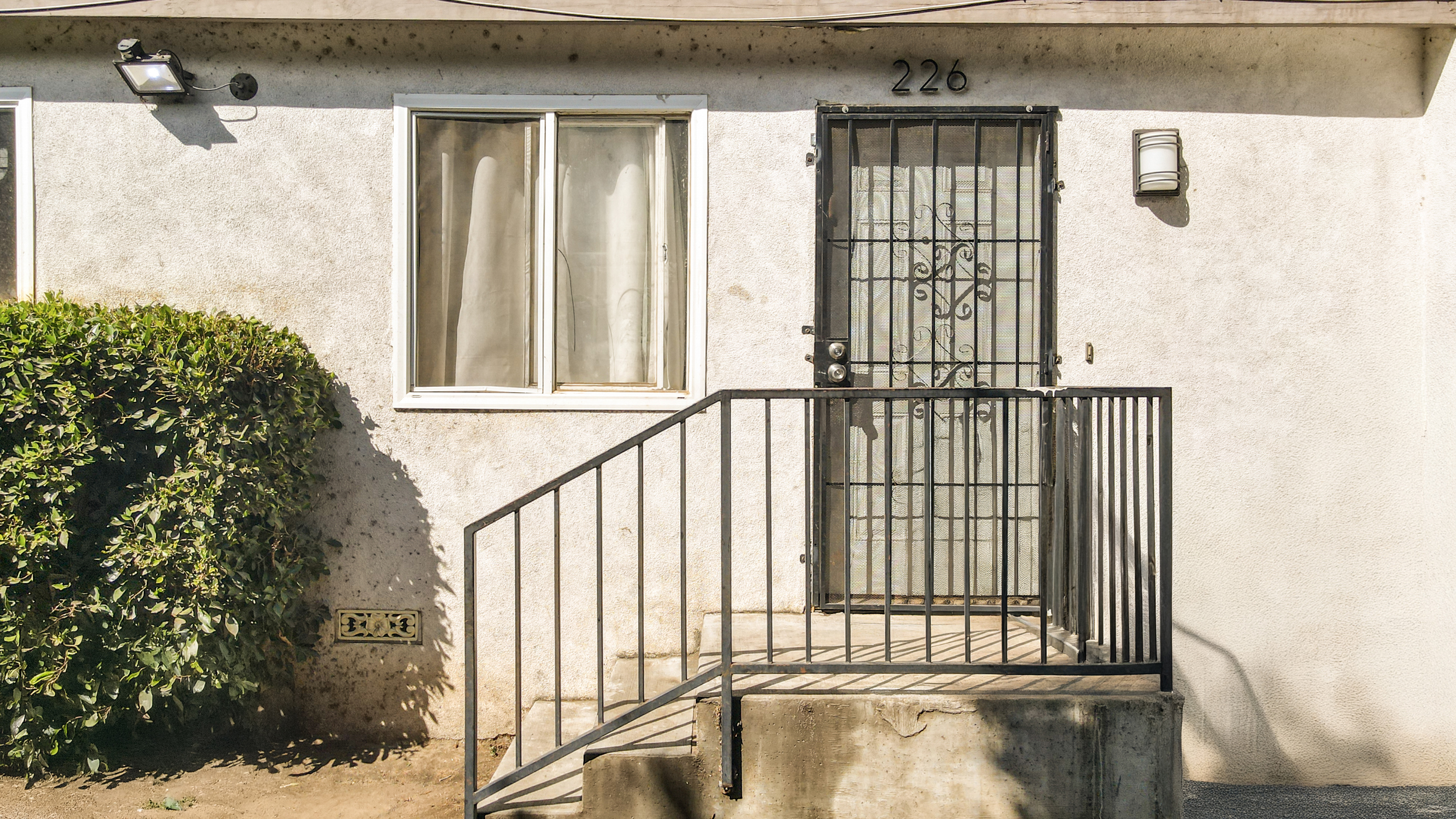 A close-up shot of the fenced backyard, showcasing the patio and space for outdoor entertaining at the triplex property.
