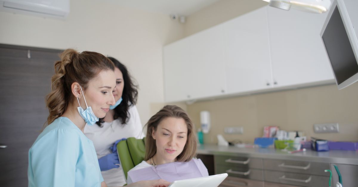 Dental team reviewing a smile plan on a tablet with a woman in the dental chair