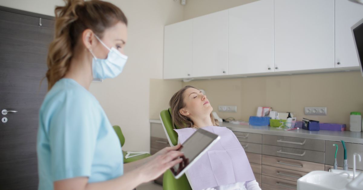 Dentist reviewing a smile plan on a tablet beside a woman in the dental chair