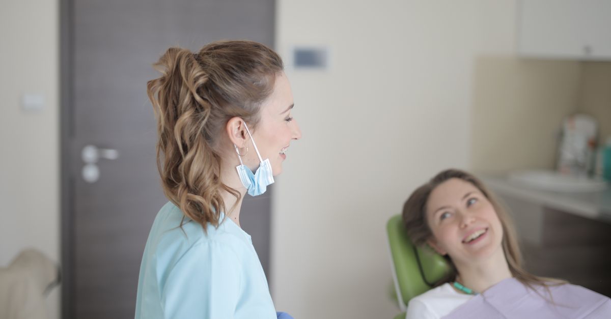 Dentist smiling and talking with a woman in a dental chair