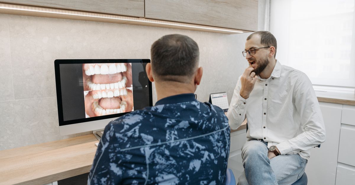 Dentist explaining dental X-ray results to a patient in a modern office