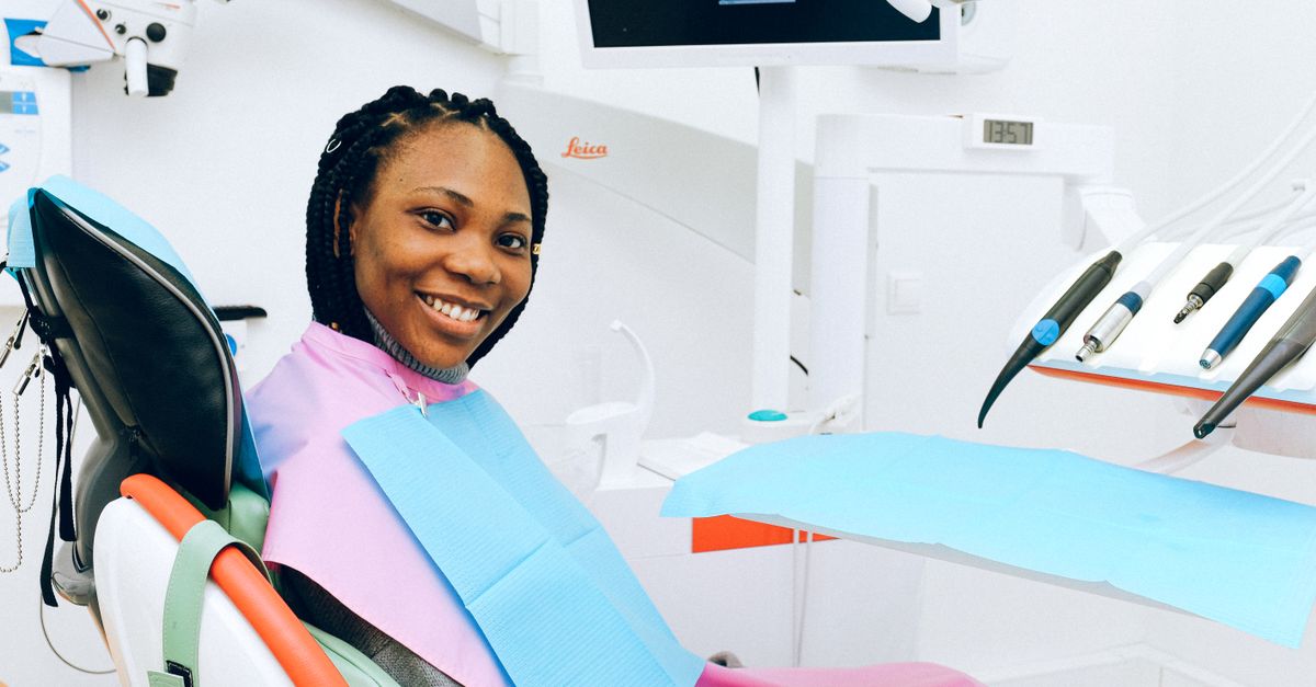 Woman smiling while sitting in a modern dental chair