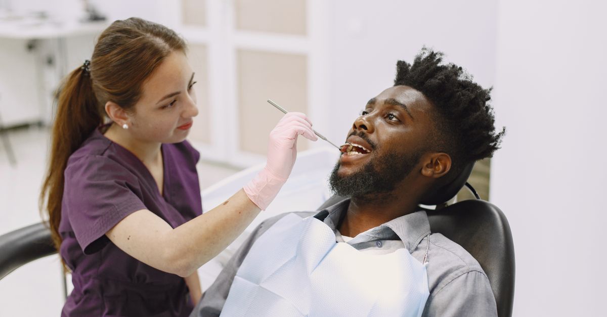Dentist examining a man's teeth in the dental chair