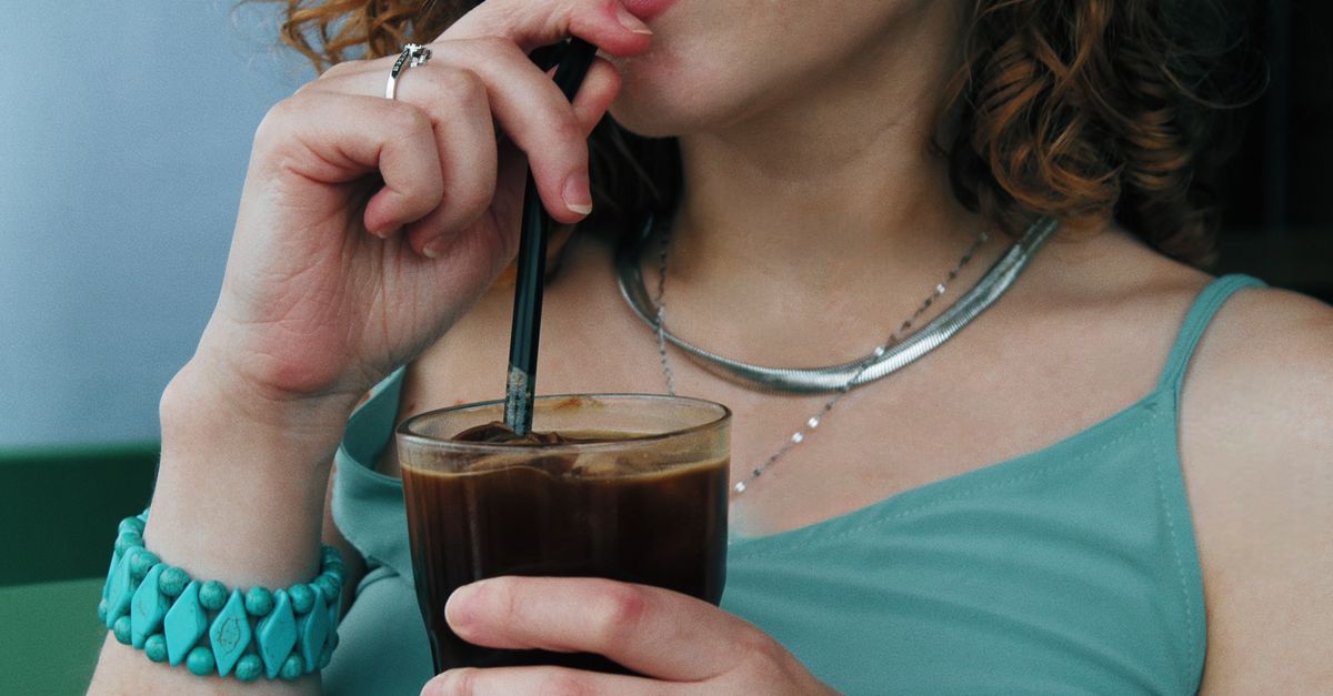 Woman sipping an iced coffee through a straw