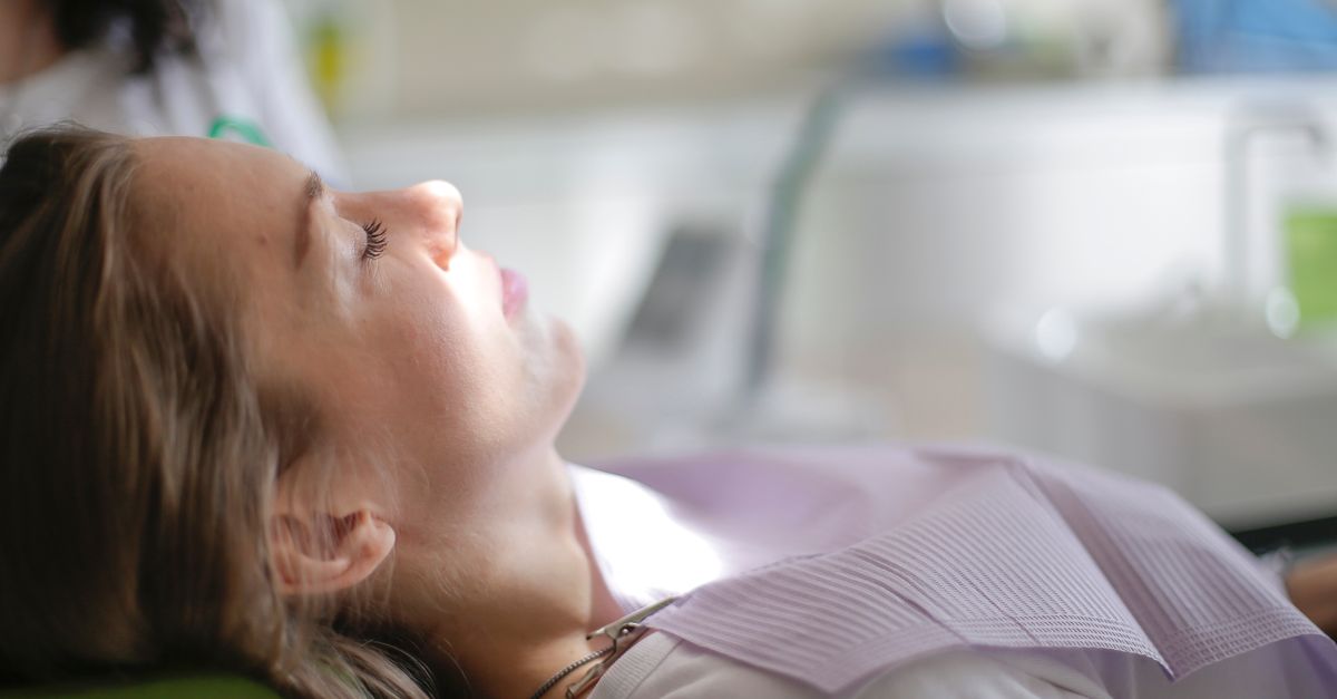 Woman resting in a dental chair with her eyes closed during a dental visit