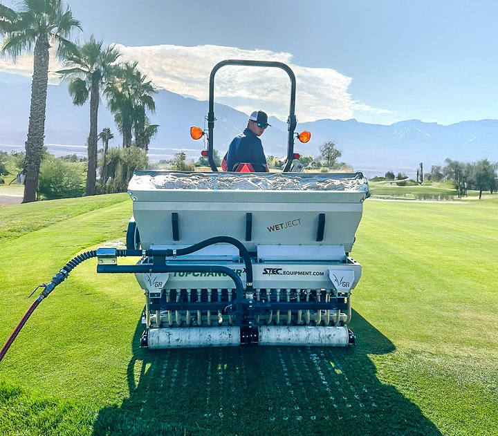 A man operating VGR TopChanger to aerate, restore balance, and improve soil in a golf course.