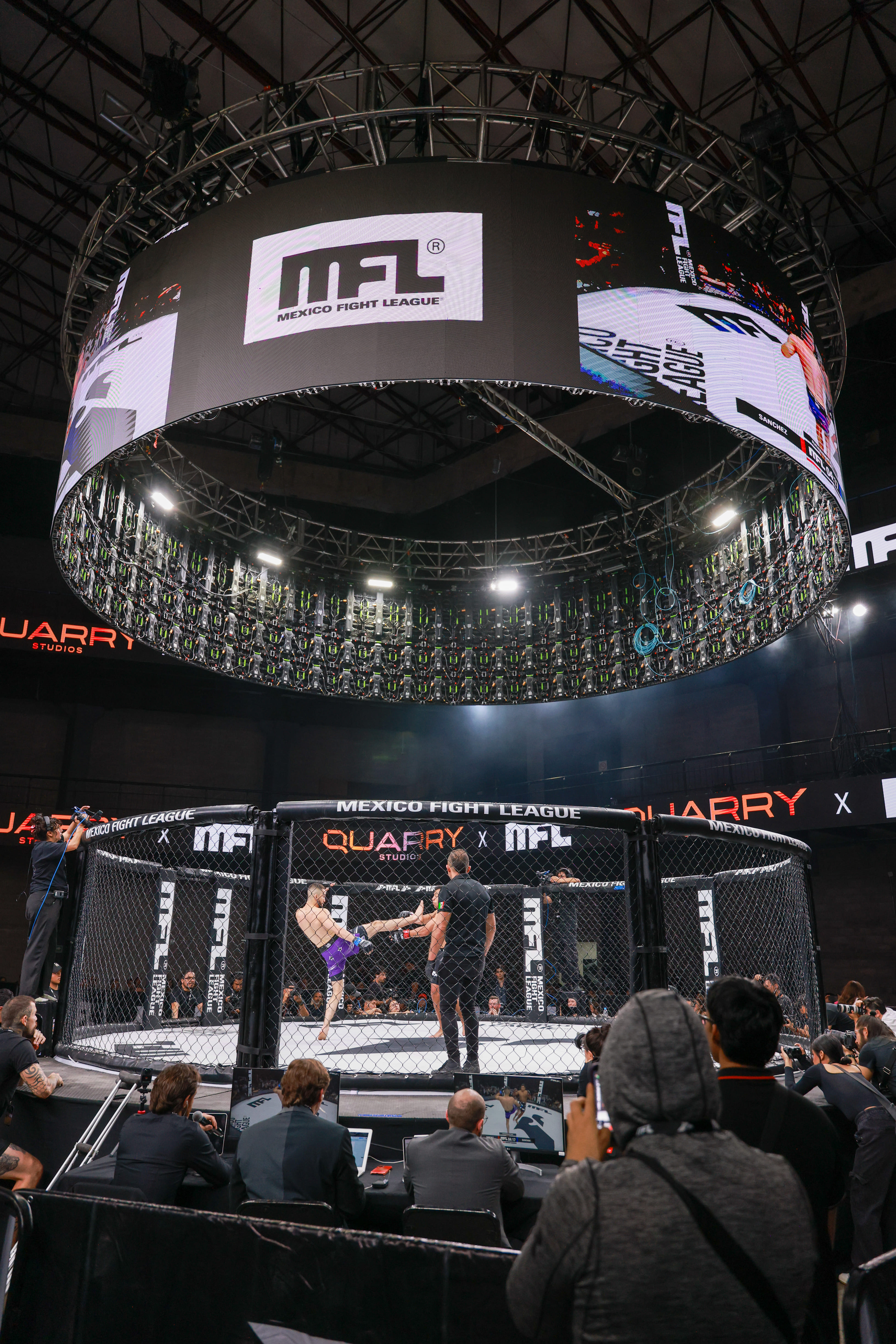 Pelea de artes marciales mixtas en jaula con pantalla y árbitro durante evento de Mexico Fight League.