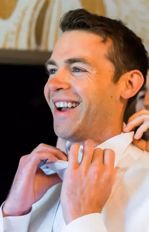 Jamie adjusting his dress shirt collar.