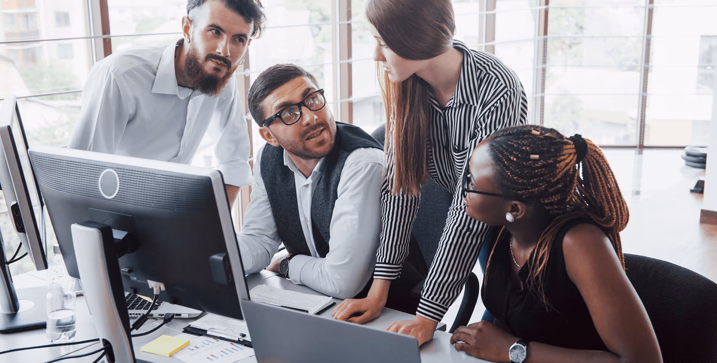 Professional headshot of smiling man in black t-shirt with white background