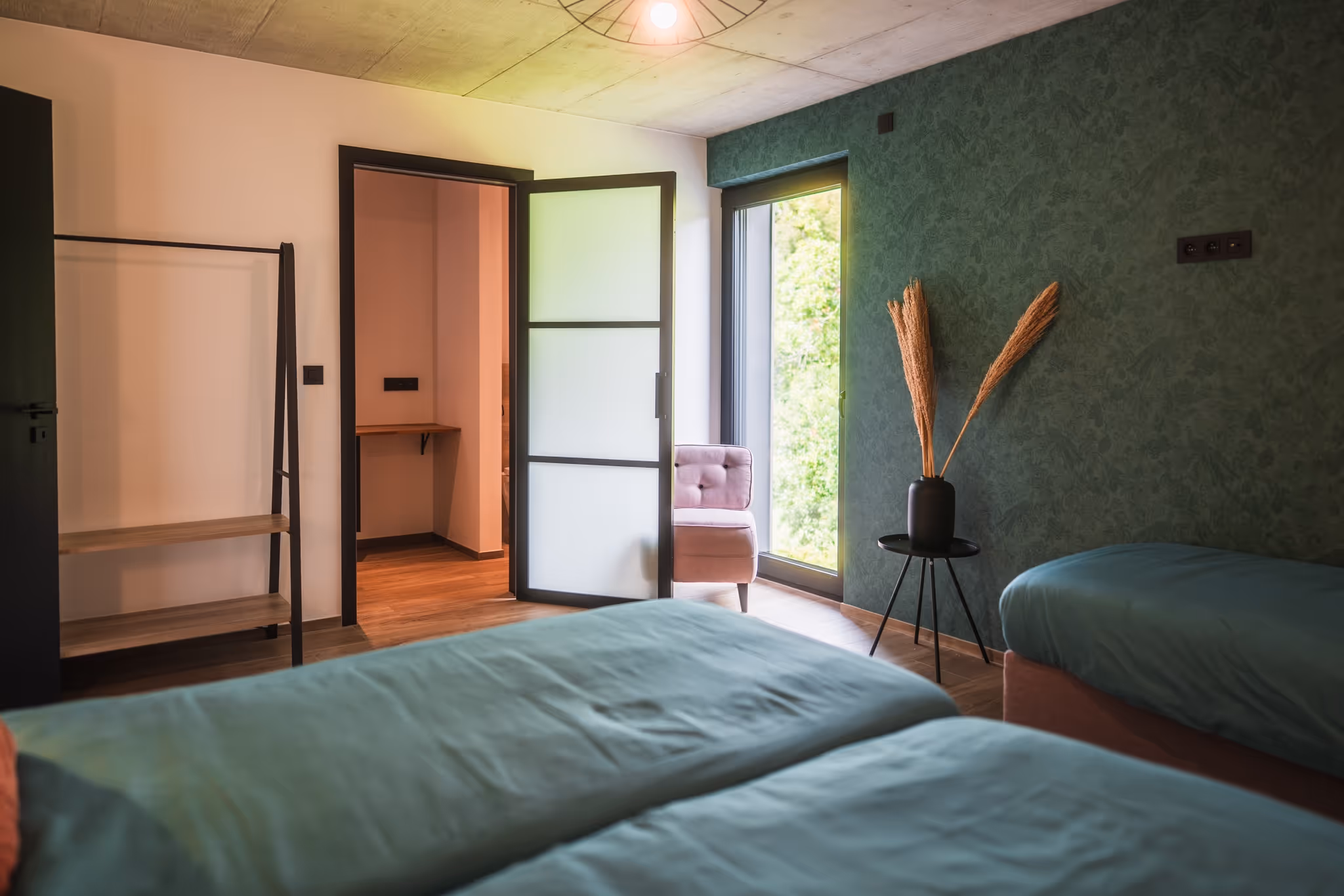 slaapkamer met tweepersoons plantenbed en badkamer