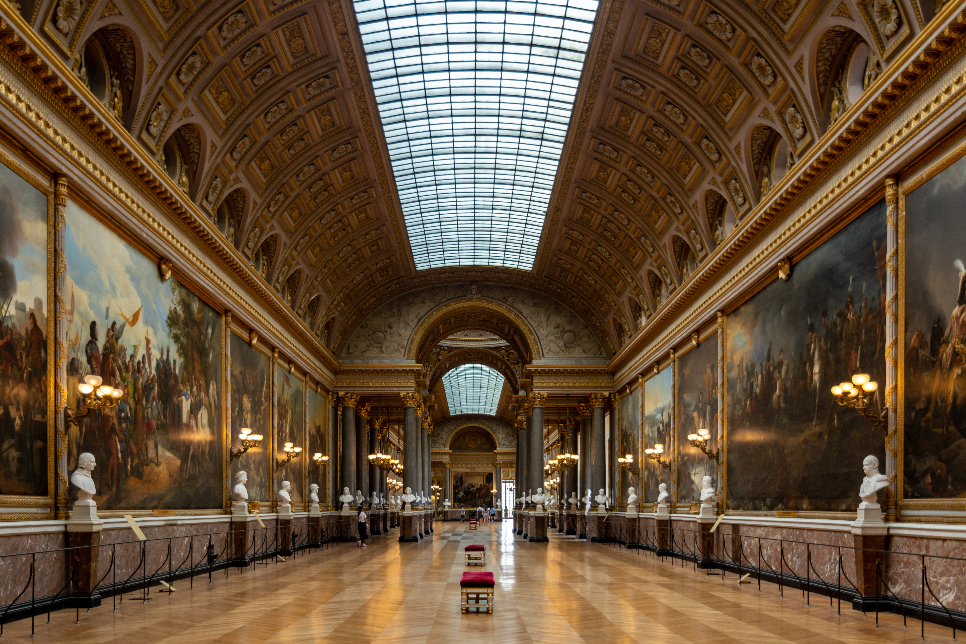 Symmetrical old-world gallery under a vaulted glass ceiling